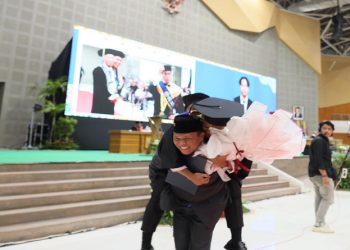 Momen Lulusan FK UMS, Ilham Hafizha Maulana Anam, S.Ked digendong Orangtuanya, Prof. Dr. Anam Sutopo, M.Hum yang juga Dekan FKIP UMS usai diwisuda, Jumat (3/4/2026). Foto: Ist.
