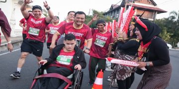 Gubernur Jawa Tengah, Ahmad Luthfi mengikuti Soekarno Run 2026 di Solo sambil mendorong kursi roda putranya, Mohammad Alif Daffa, Minggu (28/6/2026). Foto: Ist.